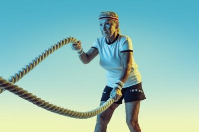 Senior Woman Training with Ropes on Gradient Wall – Free Download