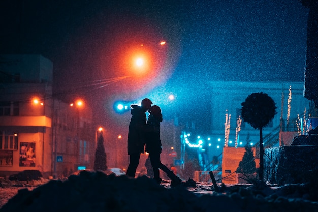 Young Adult Couple Embracing on a Snow-Covered Street – Free Download