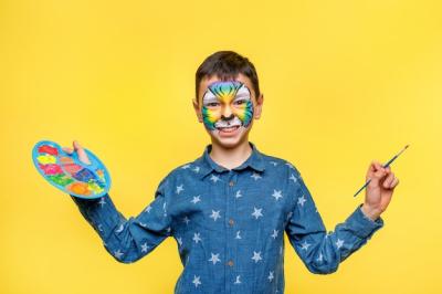 Happy Boy with Paint at a Birthday Party: Colorful Tiger Holding Palette with Gouache on Yellow Wall – Free Stock Photo, Download for Free