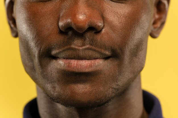 Close-Up Portrait of a Young Man Against a Yellow Wall – Free Download