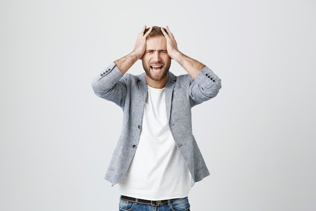 Depressed Young Man Grabbing Head and Shouting – Free Stock Photo Download