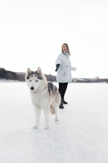 Happy Young Girl Playing with Siberian Husky Dog in Winter Park – Free Download