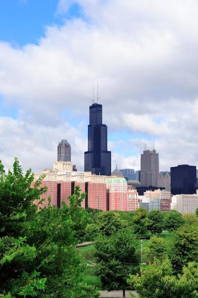 Chicago Skyline Surrounded by Trees and Law Under a Cloudy Blue Sky – Free Download