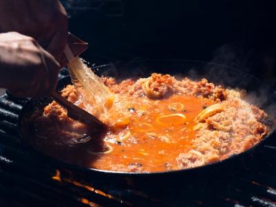 Cook Adding Sauce to Rice with Calamari Rings and Vegetables – Free Stock Photo for Download