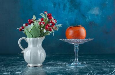 Tasty Ripe Persimmon on Glass Plate with Vase of Flowers – Free Download