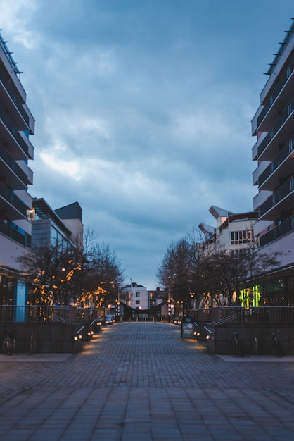 Walkway Surrounded by Buildings Under a Clouded Sky – Free Stock Photo for Download