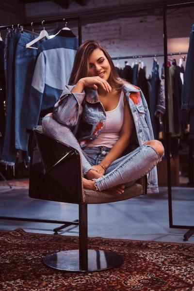 Cheerful Girl in Distressed Jeans and Denim Jacket in Clothing Store Fitting Room – Free Download