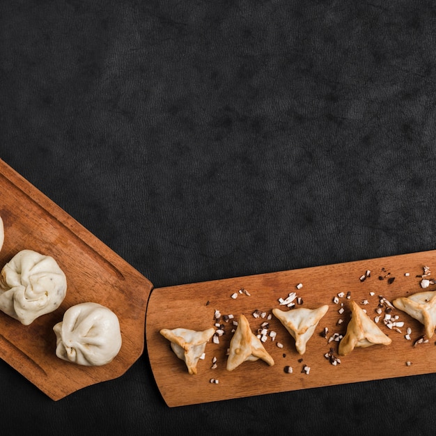 An Elevated View of Dumplings on Wooden Tray Against Black Background – Free Stock Photo for Download