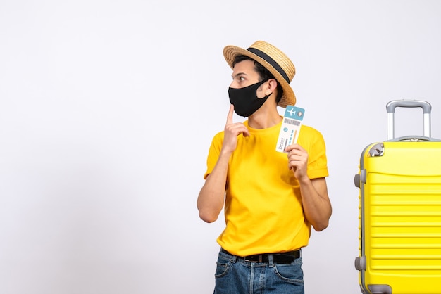 Interested Young Man with Straw Hat Near Yellow Suitcase Holding Travel Ticket – Free Download