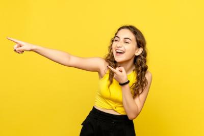 Young Woman Laughing Against a Yellow Wall – Free Stock Photo, Download Free