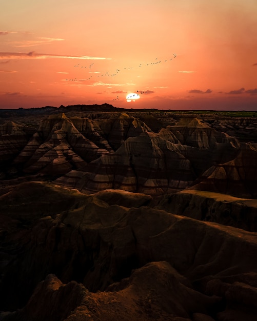 Sunset Over Badlands: Terrain with Striped Rock Formations – Free to Download