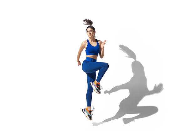 Portrait of a Beautiful Young Female Athlete in Motion on a White Studio Background – Free Download