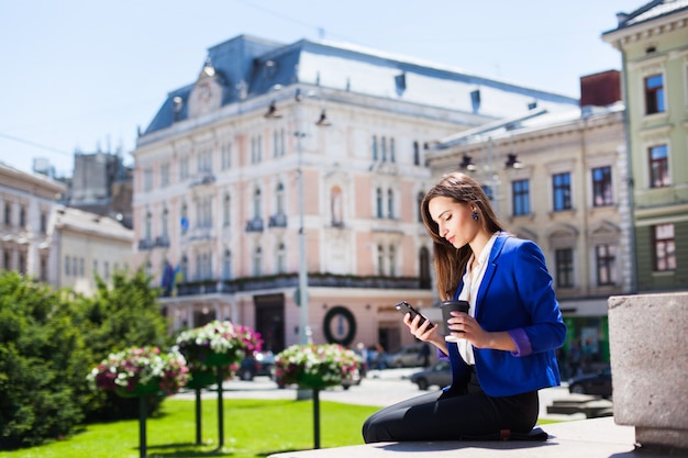 Woman with Coffee on the Street Checking Her Phone – Free Stock Photo for Download