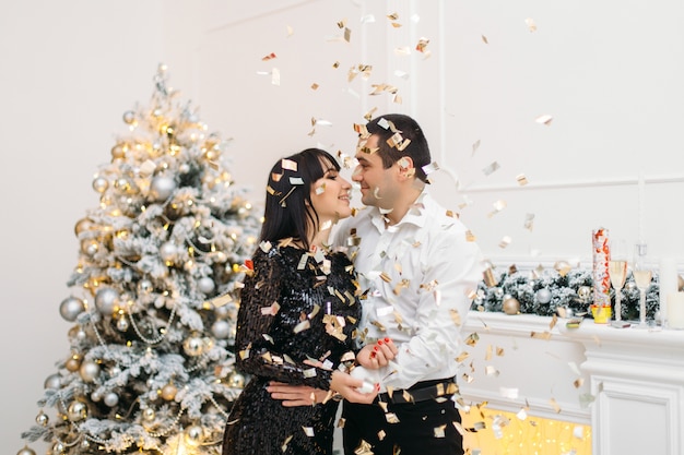 Festive Dinner Couple in Front of Shiny Christmas Tree – Free Stock Photo