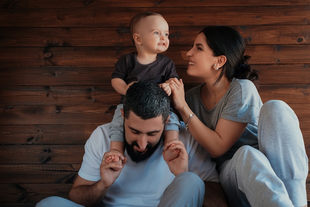 Joyful Family Moments: Baby on Father’s Shoulders and Playing with Mother – Free Download