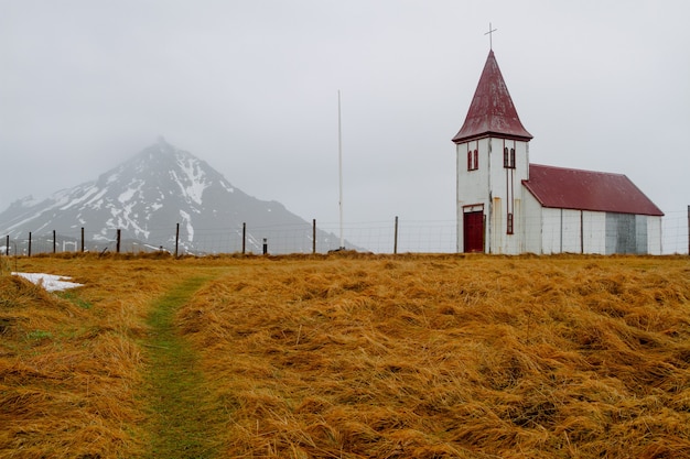 Church with a Red Roof Surrounded by Rocks Under a Cloudy Sky in Iceland – Free Download