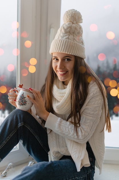 Young Attractive Woman Enjoying Hot Tea at Christmas with Cozy Winter Background | Free to Download