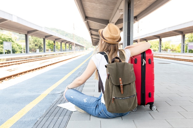 Woman Sitting on the Floor at the Train Station – Free Download