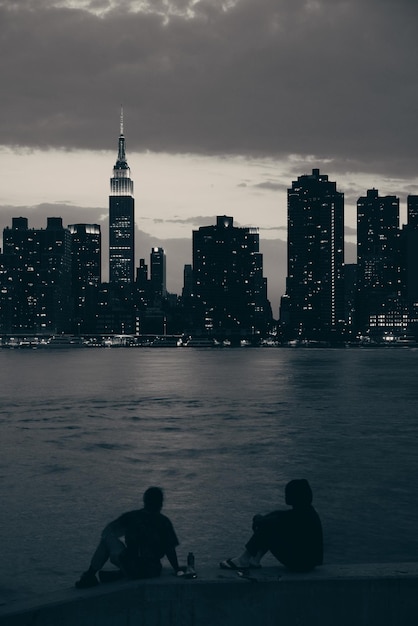 Two Men Enjoying a Night View of Manhattan – Free Download