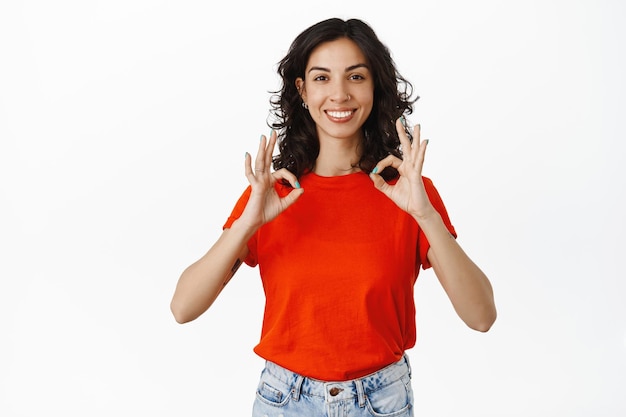 Smiling Woman Giving a Compliment with OK Gesture on White Background – Free Download