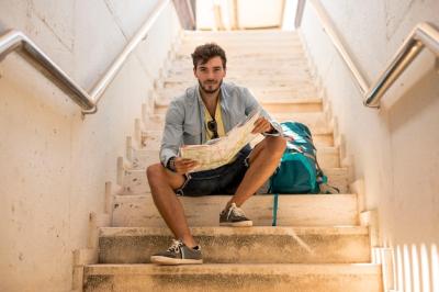 Traveler Sitting on Stairs Looking at Camera – Free Stock Photo for Download