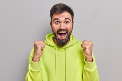 Cheerful Bearded Man Celebrating Success in Victory Gesture – Free Stock Photo, Download for Free