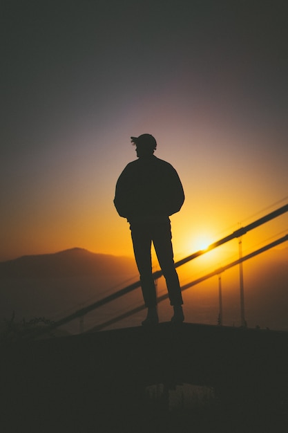 Silhouette of a Young Male on a Staircase with Sunset View – Free Download