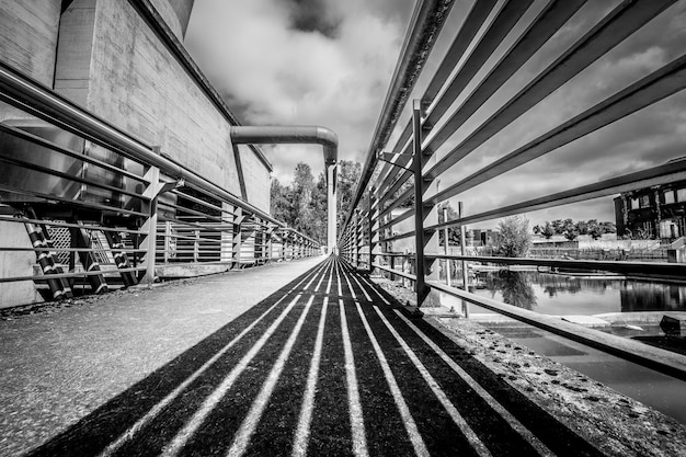 Grayscale Shot of a Bridge Under a Cloudy Sky – Free to Download