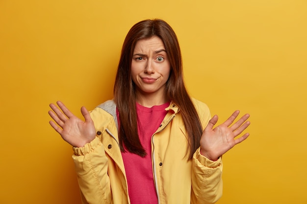 Indignant and Clueless Woman with Puzzled Expression in Yellow Jacket – Free Stock Photo Download