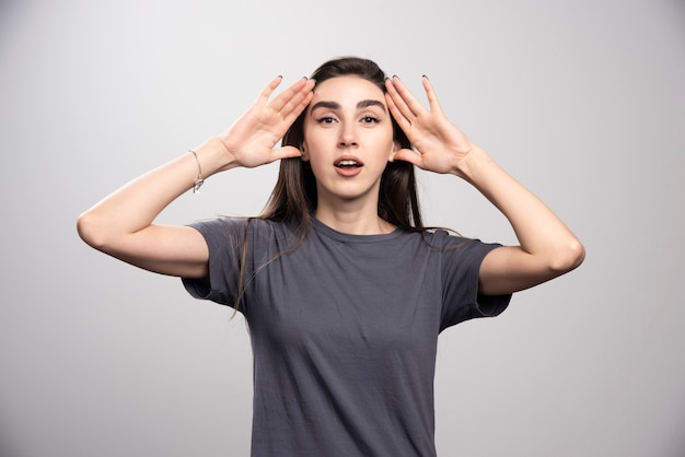 Young Woman Touching Head Against Gray Background – Free Download