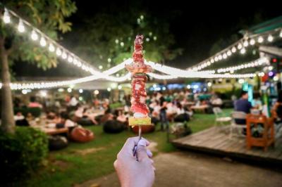 Cropped Hand Holding Food in Stick at Illuminated Restaurant – Free Stock Photo, Download for Free