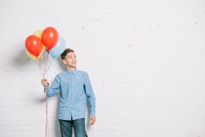 Teenage Boy Holding Balloons While Looking Away – Free Download