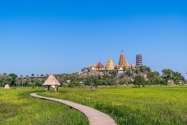 Tiger Cave Temple Wat Tham Suea in Kanchanaburi, Thailand Surrounded by Lush Green Rice Fields – Free Download