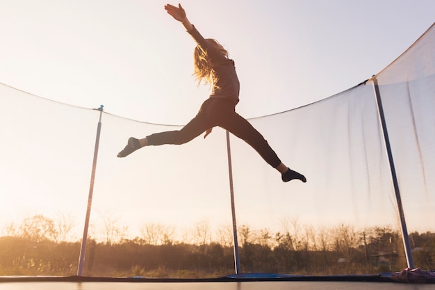 Active Little Girl Jumping on a Trampoline Against the Sky – Free Stock Photo for Download