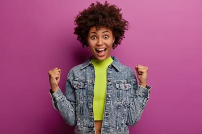 Triumphant Woman with Afro Hairstyle Smiling as a Champion – Free Stock Photo for Download