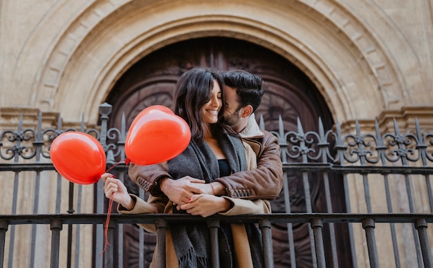 Romantic Moment of Man Embracing Woman by the Fence – Free Download