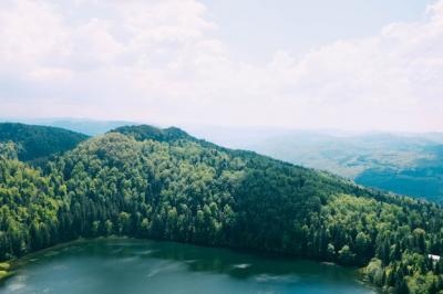 Beautiful Lake Surrounded by Tree-Covered Mountains Under a Cloudy Sky – Free Stock Photo for Download