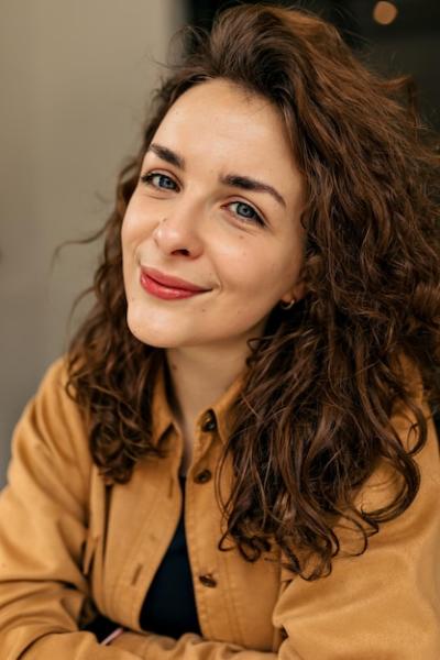 Close-Up Portrait of a Tender Woman with Curly Hair and Nude Makeup – Free Stock Photo