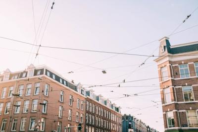 Low Angle View of Electricity Wires Against Brown Concrete Buildings – Free Stock Photo for Download