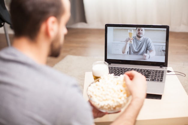 Video Call Moments: Friend Enjoying Beer and Popcorn During Quarantine – Free Download