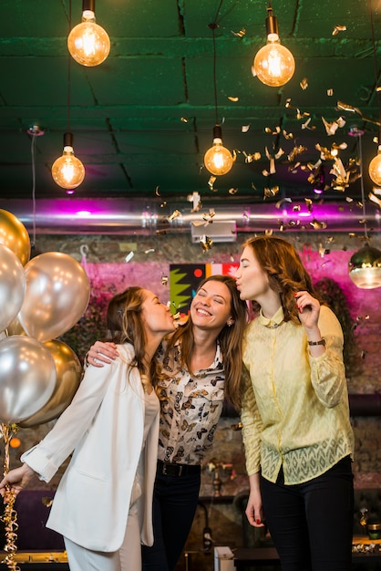 Young Smiling Friends Kissing at a Party – Free Stock Photo, Download for Free