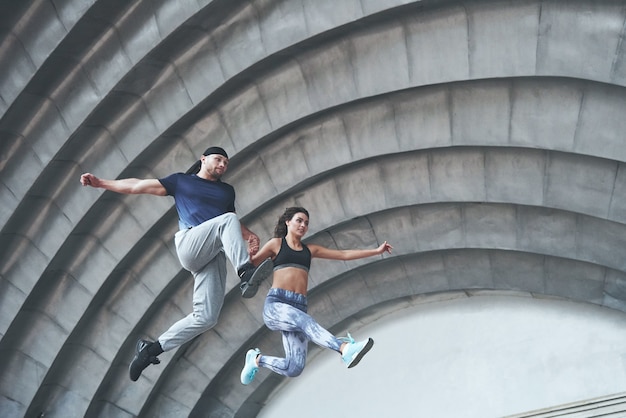 Young Happy Sports Couple Performing Parkour in the City Street – Free Download