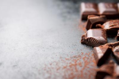 Chocolate Tablet on a Black Wooden Table with Cacao Sprinkles – Free Download