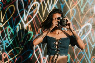 Cheerful Woman Using an Instant Camera – Free Stock Photo for Download