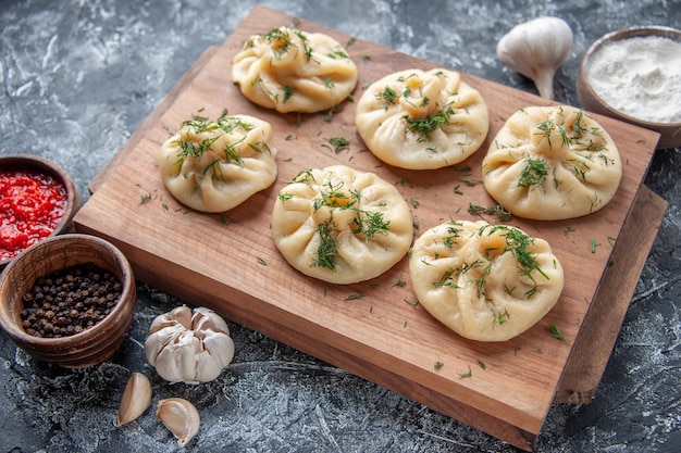 Raw Little Dumplings with Meat and Tomato Sauce on Gray Surface – Free Download