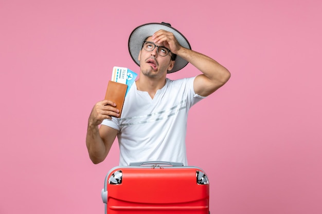 Young Man Holding Vacation Tickets on a Pink Wall – Free Download