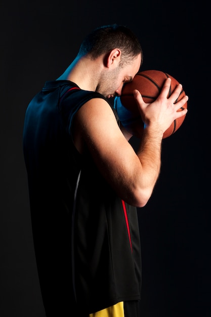 Side View of Basketball Player Holding Ball to Forehead – Free Download