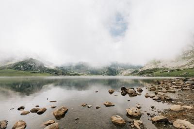 Mesmerizing View of a Lake Surrounded by Misty Mountains – Free Stock Photo for Download