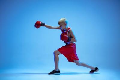 Novice Male Caucasian Boxer Training in Sportswear Against a Neon Blue Background – Free Download