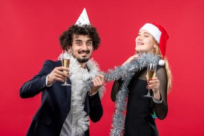 Young Couple Celebrating New Year Against a Red Wall – Free Download